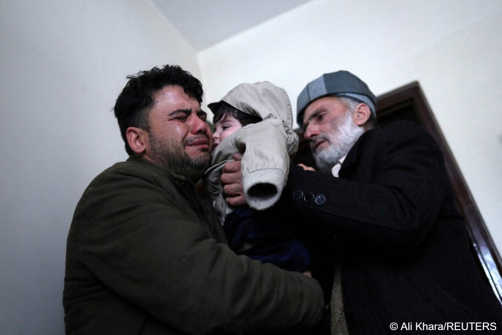 Hamid Safi, a 29-year-old taxi driver who had found baby Sohail Ahmadi in the airport, cries as he hands over Sohail to his grandfather Mohammad Qasem Razawi in Kabul, Afghanistan, January 8, 2022 | Photo: REUTERS/Ali Khara
