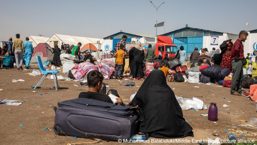 File photo: Afghan families rest on the ground after being deported from Iran at the Islam Qala crossing in Afghanistan on July 4, 2025 | Photo: Muhammad Balabuluki / Middle East Images / picture alliance
