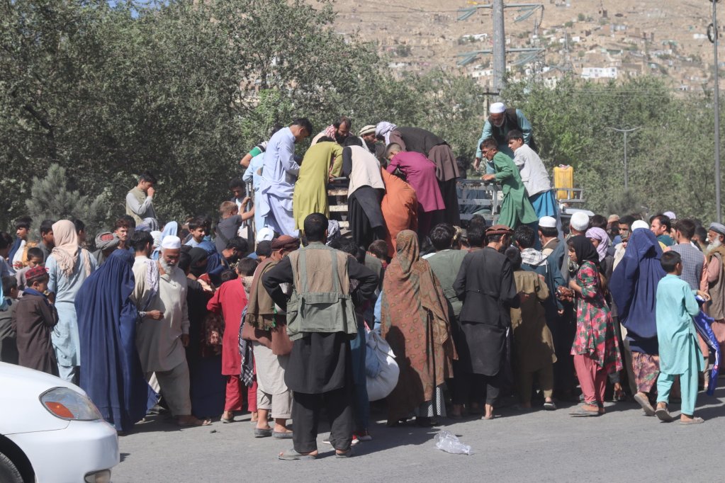الأفغان الذين نزحوا من ولايتي قندوز وتخار بسبب القتال بين طالبان والقوات الأفغانية يتجمعون لجمع الغذاء،يعيشون في ملاجئ مؤقتة في معسكر في كابول ، أفغانستان ، 10 أغسطس 2021