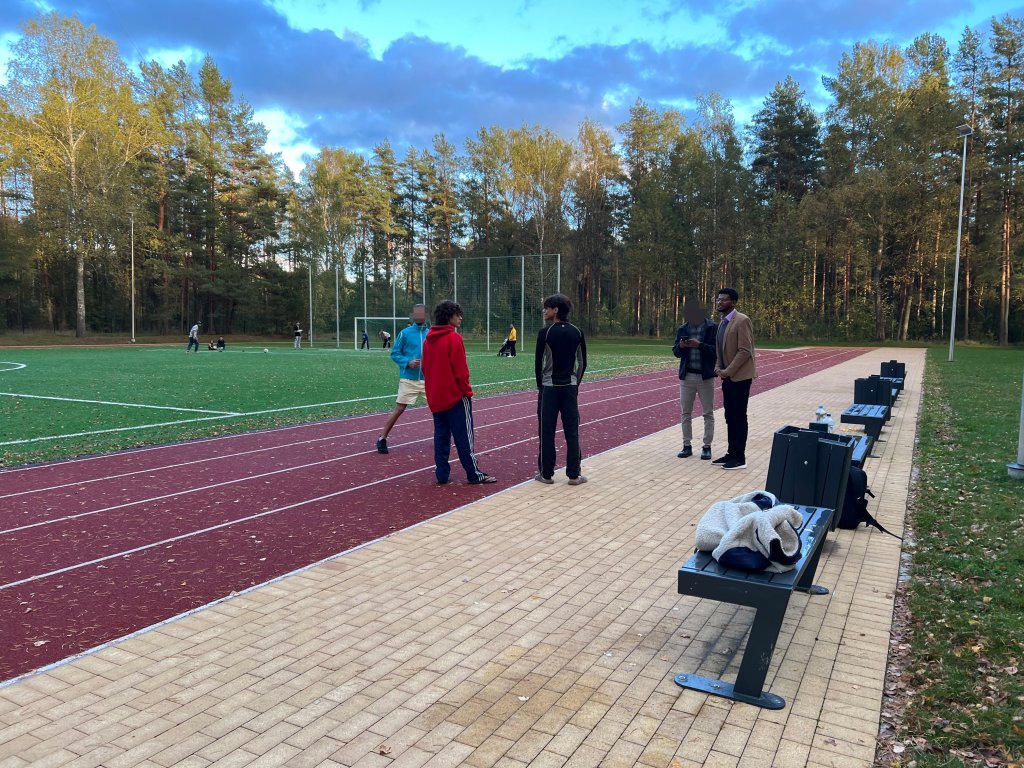 Abbas, Musab, Saleh and other migrants standing next to a soccer field in the village of Mucenieki in Latvia on September 29, 2024 | Photo: Benjamin Bathke/InfoMigrants