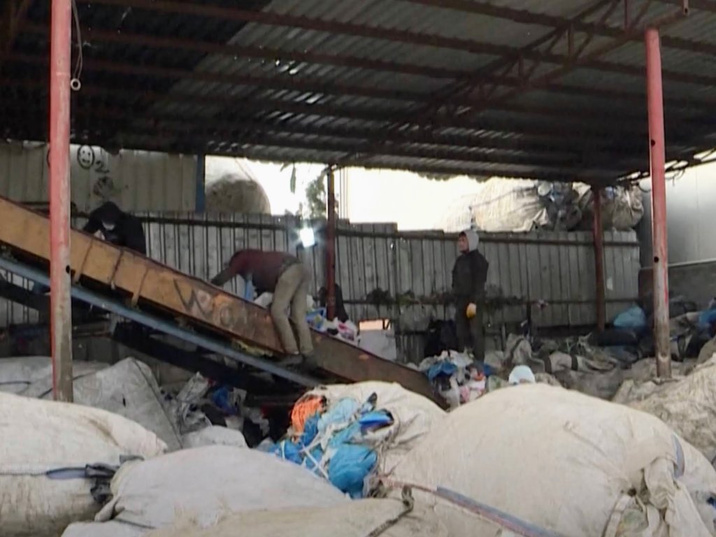 Migrants work 12-hour days to sort through trash, making less than $10 | Screenshot: AFP video via DW