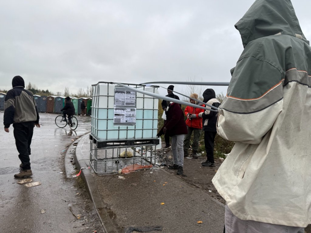 Two water tanks and a portable toilet are the only access to sanitation near the Calais camp, November 27, 2025 | Photo: InfoMigrants