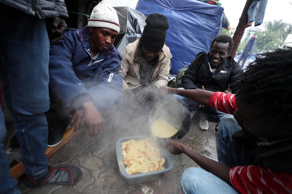From file: Sub-Saharan African migrants eat at a makeshift camp outside the International Organisation for Migration headquarters in Tunis, Tunisia. The camps were cleared last week, reports suggest that around 400 people in the camp may have been expelled to the borders | Photo: ARCHIVE/EPA/MOHAMED MESSARA