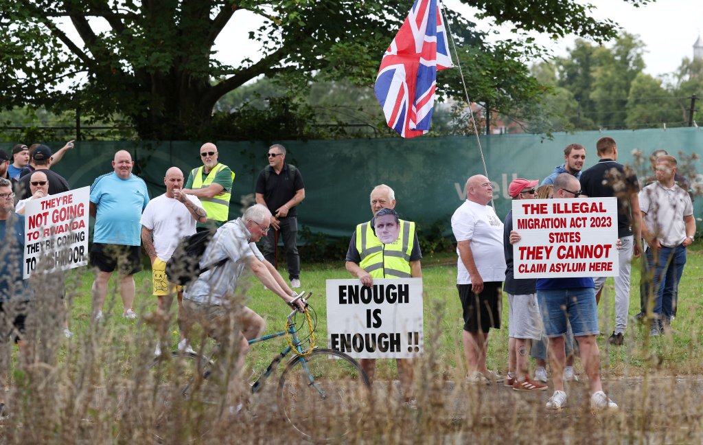 Des manifestants brandissent des slogans anti-immigration, à Aldershot, dimanche 4 août 2024. Crédit : Reuters