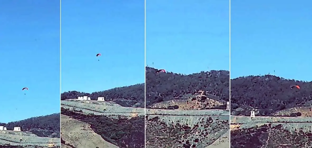 Un migrant passe au dessus de la frontière de Ceuta en parapente. Crédit : capture d'écran Facebook