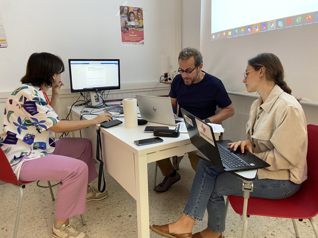 At the Spanish Red Cross offices in Santa Cruz de Tenerife, José Pablo Baraybar of the ICRC trains Isabel Sebastia Fabregat (left) and Silvia Cruz Oran (right) in the use of SCAN. Photo: InfoMigrants