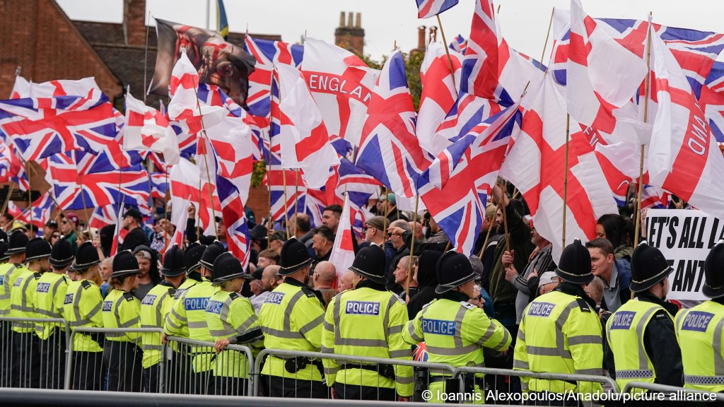 Supporters of the far-right Britain First party wave Union Flags and St George's flags during an anti-immigration rally in Tamworth, United Kingdom, on September 12, 2026 | Photo: Joannis Alexopoulos/Anadolu