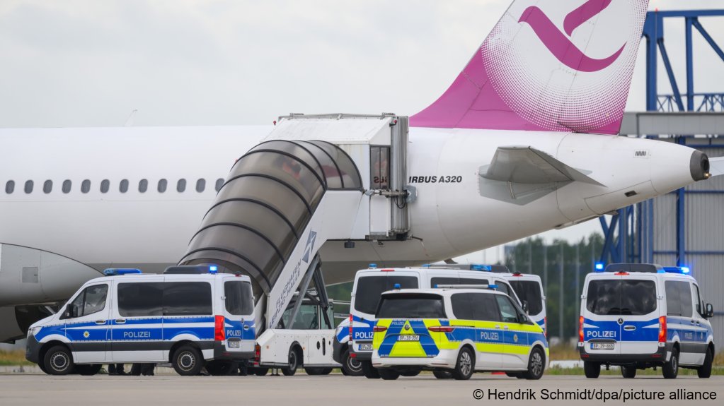 Police officers and a police vehicle stand at the foot of the stairs of the plane on which the Yazidi family were deported  Photo: Hendrik Schmidt/dpa/picture alliance
