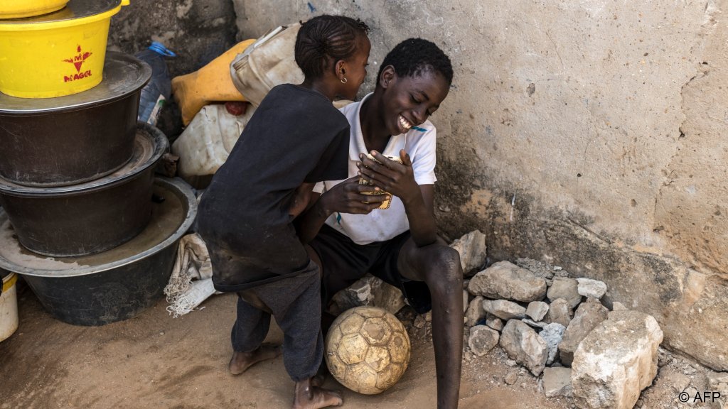 Coumba (L) plays with her brother Boubacar (R) outside their home in Mbour. Coumba asks about her father a lot, but has been told he is 'on a trip' the reality, thinks Boubacar would 'send her crazy' | Photo: Patrick Meinhardt / AFP