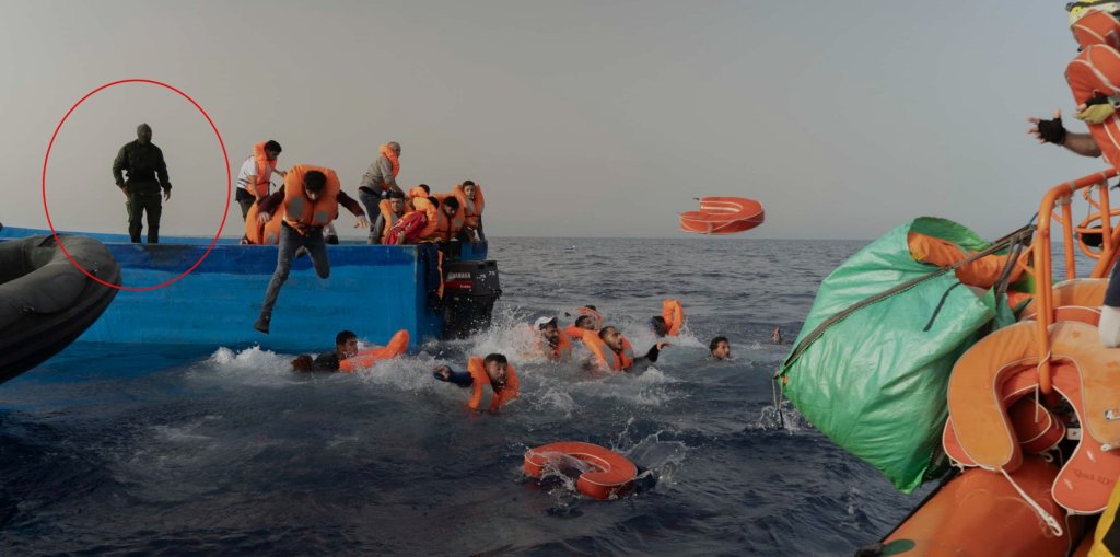 رجل مسلح وملثم مجهول الهوية يثير الذعر على متن قارب يحمل مهاجرين، في 9 تموز/ يوليو 2024.
حقوق الصورة: SOS Méditerranée