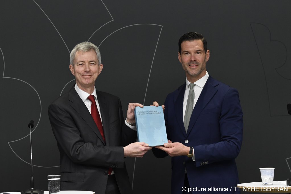 Minister for Migration Johan Forssell (r) receives the report 'Stricter requirements for an honest lifestyle and increased possibilities for revoking residence permits' from the special investigator Robert Schött (l) | Photo: Viktoria Bank / TT/ picture alliance