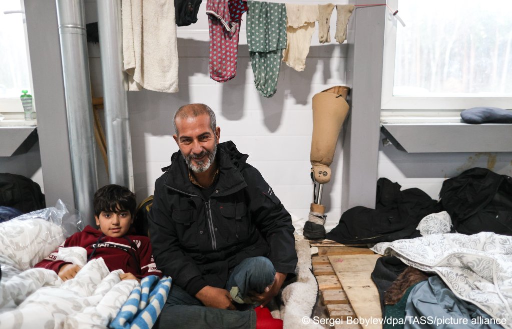  A disabled refugee and a child at the Bruzgi Transport and Logistics Centre on November 21, 2021 | Photo: Sergei Bobylev/TASS/dpa/picture-alliance
