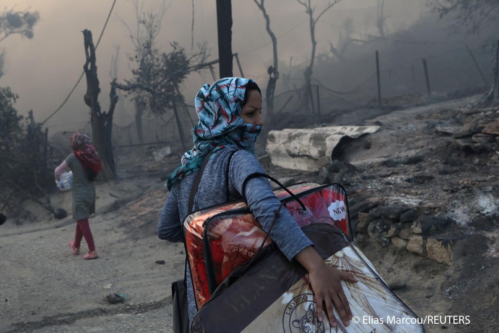 امرأة تحمل متعلقاتها بعد حريق في مخيم موريا للاجئين والمهاجرين في ليسبوس ، اليونان