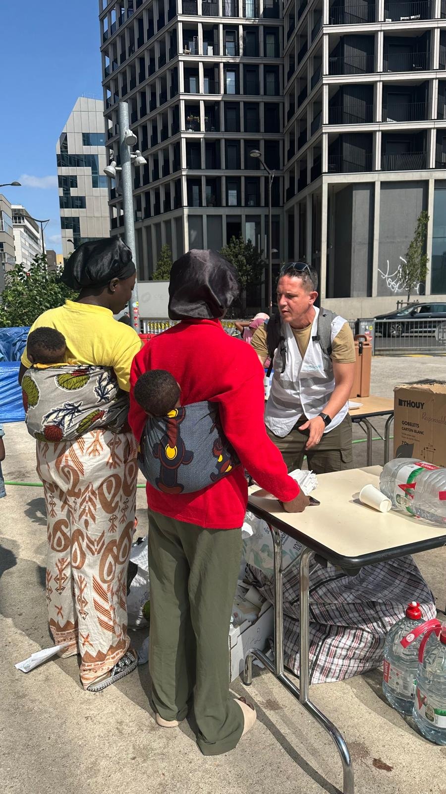 Kone Kariatou, 28, and Dosso Massandge, 23, both from Ivory Coast, with a volunteer from Utopia 56, in Paris, July 22, 2026. Photo: InfoMigrants