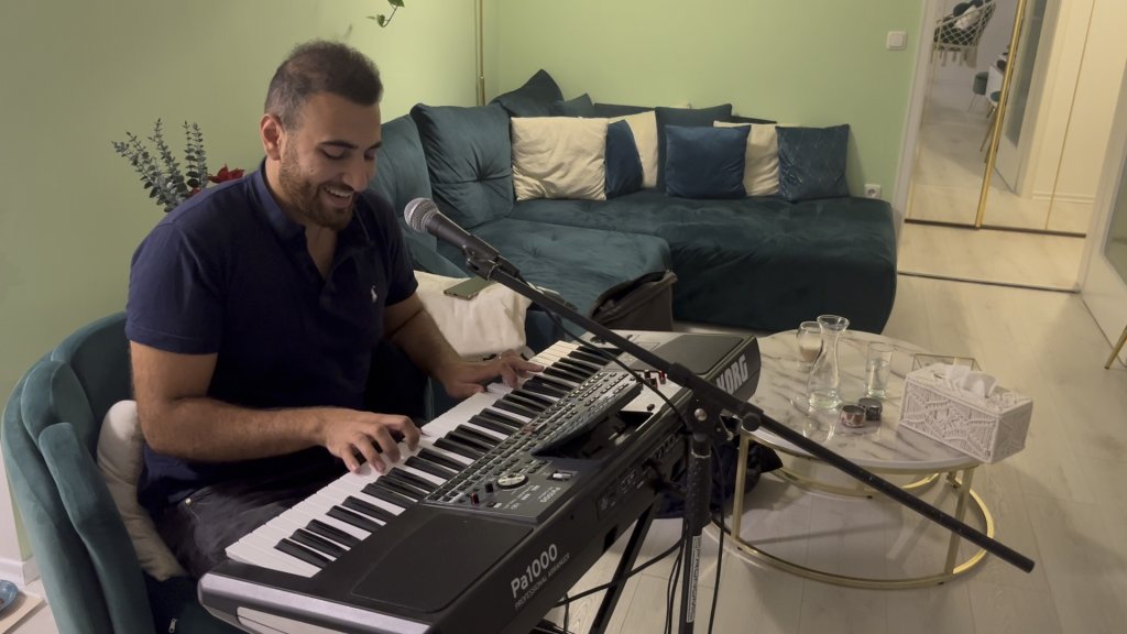 Uday Alturk playing his keyboard. He arrived as a minor in 2014 with his family and now works as a driving instructor and plays music and football in his spare time. | Photo: Natasha Mellersh / InfoMigrants