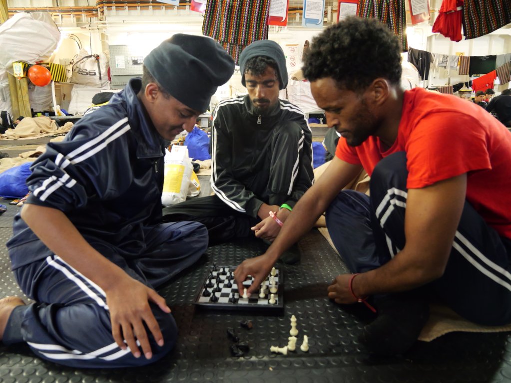 Three Ethiopian men play a game of chess on board the Geo Barents, February, 2024 | Photo: Sou-Jie van Brunnersum