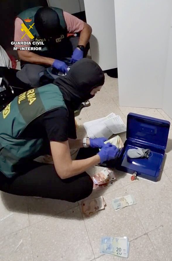 Spanish police officers find cash, as well as mobile phones and electronic devices during raids into a gang accused of exploiting unaccompanied migrant minors who arrived on the Canary Islands | Source: Guardia Civil press release