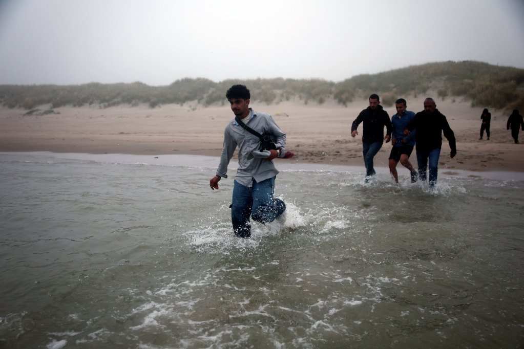 A group of migrants go into the water from the beach at Petit-Fort-Philippe beach in Gravelines, near Calais, to reach a boat and cross the English Channel. July 2, 2025 | Photo: Reuters