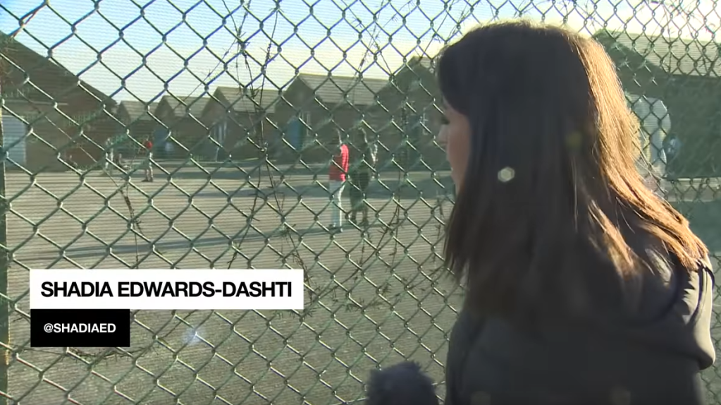 Shadia Edwards-Dashti reporting for RT through the fence at the Napier Barracks | Source: Screenshot RT