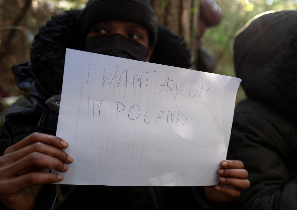 From file: A Somali migrant holds up a sign as he sits in the forest after crossing the Belarusian-Polish border in Siemianowka, Poland, October 25, 2021 | Photo: Reuters