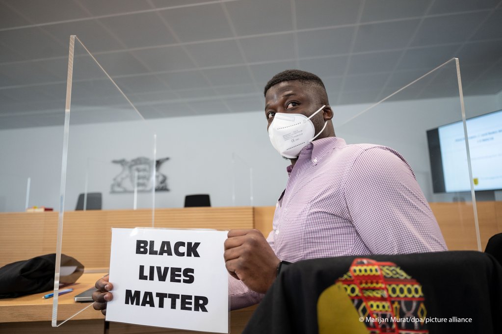 A Cameroonian asylum seeker holds a sign that reads "Black Lives Matter" before his trial about his lawsuit against the German state of Baden-Wuerttemberg | Photo: Marijan Mura/picture-alliance/dpa