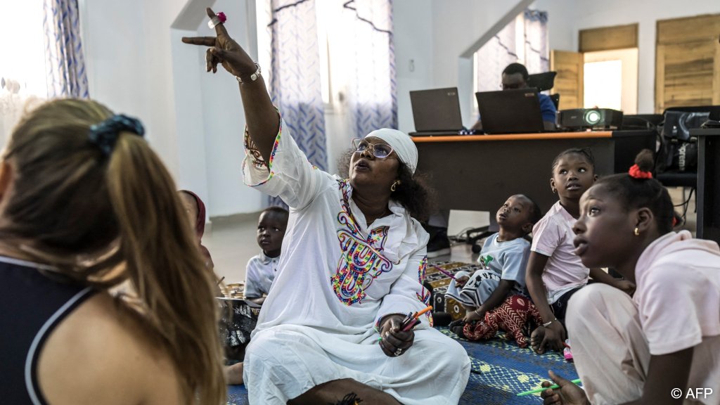 Psychotherapist Mame Katy Faye points to a screen during a psychosocial support session with children who have lost family members at sea trying to reach Europe through the Atlantic route | Photo: Patrick Meinhardt / AFP