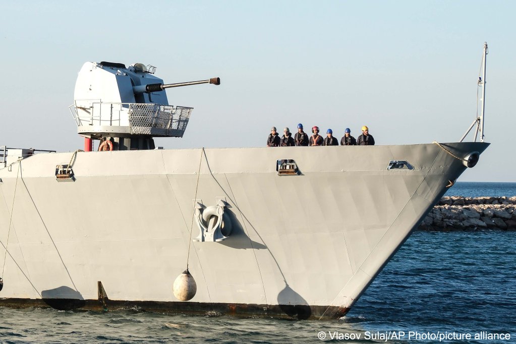 Security official stands on the Italian navy ship Libra as it arrives at the port of Shengjin northwestern Albania Wednesday, Oct. 16, 2024, carrying the first group of migrants to be processed there, but can the model really work?| Photo: Vlasov Sulaj/AP Photo/picture alliance