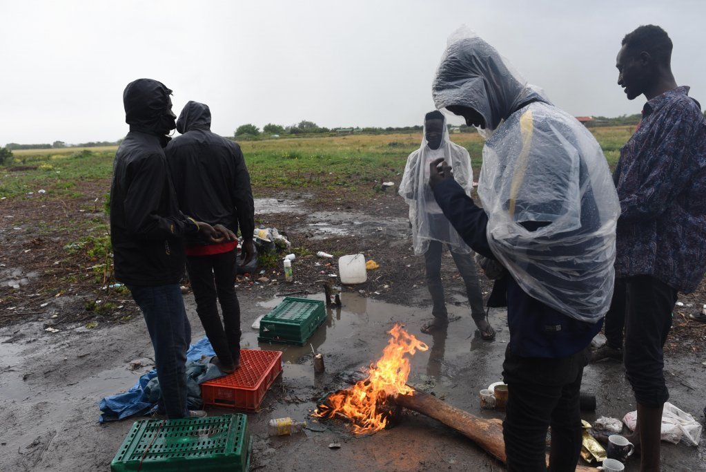 From file: In a camp in Coquelles, close to Calais, Sudanese migrants warm themselves by a fire because they have no tent to protect them from the rain | Photo: Mehdi Chebil / InfoMigrants