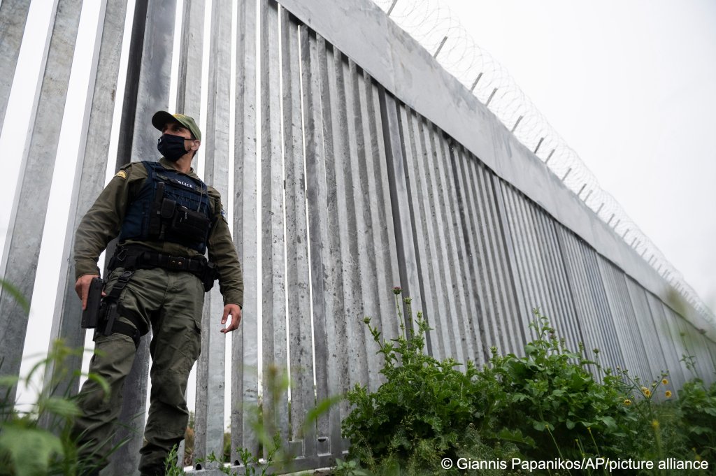 A police officer patrols alongside a steel wall at Evros river, near the Greek village of Poros, at the Greek-Turkish border on May 21, 2021. An automated hi-tech surveillance network aims at detecting migrants early and deterring them from crossing | Photo: Giannis Papanikos/AP Photo