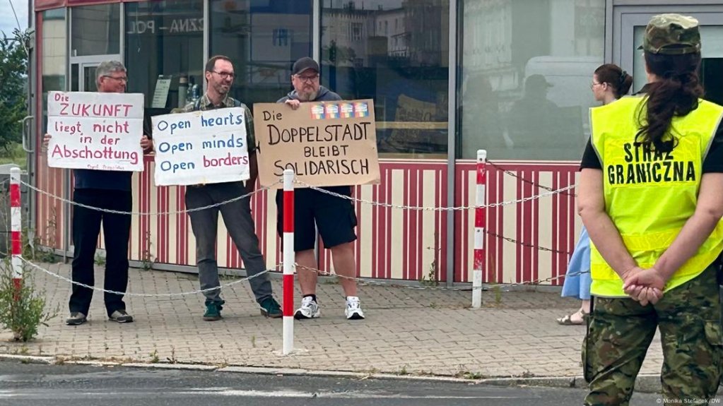 Three men from the Frankfurt Remains Colorful network hold up signs supporting an open border between Germany and Poland | Photo: Monika Stefanek/DW
