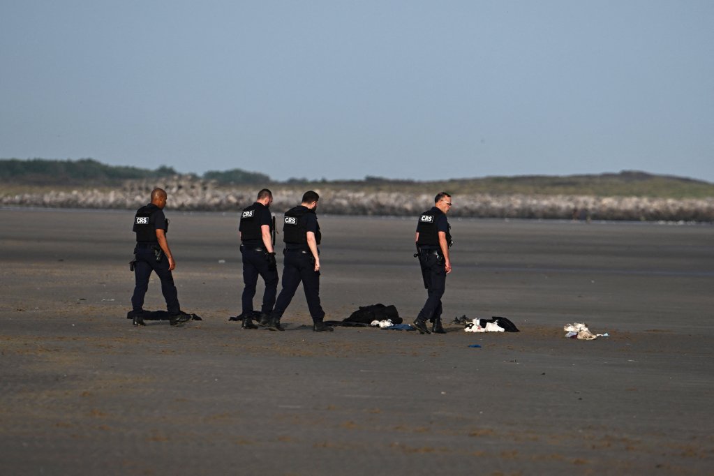 Police officers walk next to abandoned belongings left by migrants after they boarded and inflatable dinghy before leaving the coast of northern France in an attempt to cross the English Channel to reach Britain, on the beach of Petit-Fort-Philippe in Gravelines, near Calais, France, May 23, 2026 | Photo: REUTERS/Dylan Martinez