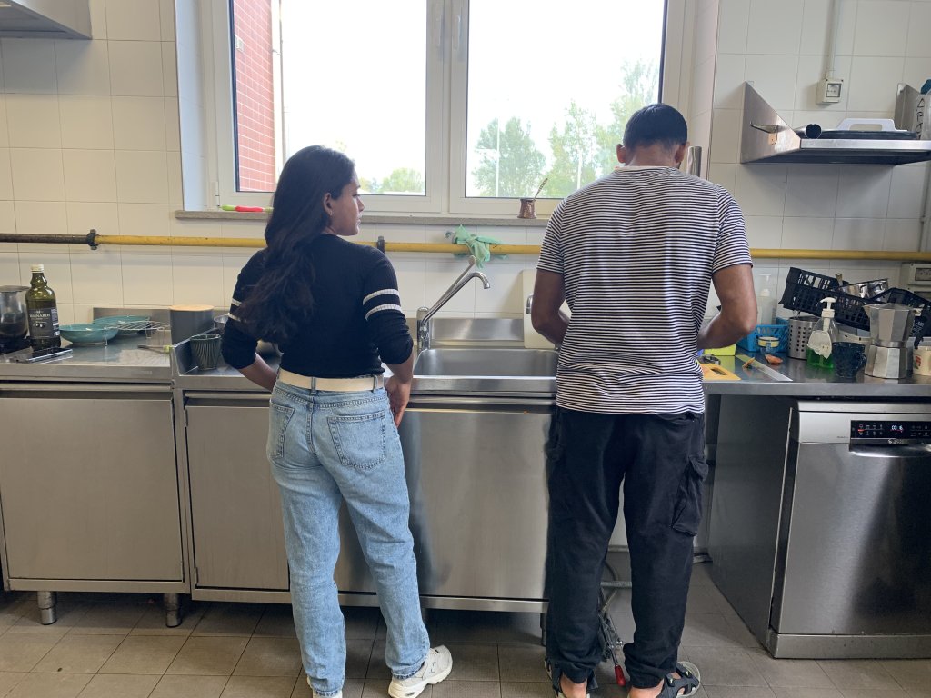 Suratun Fatiha Protiti (L) whose parents are from Bangladesh works as a social worker in the house for unaccompanied minors in Monfalcone. Today, she and one of the residents, a young man from Pakistan, are on duty to prepare the lunch for everyone else | Photo: Emma Wallis / InfoMigrants