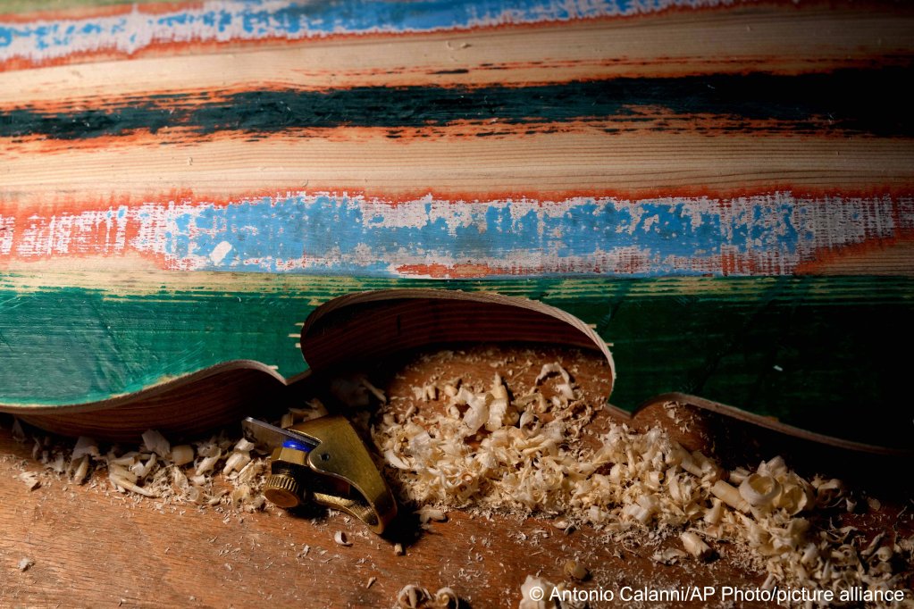A violin carved from the wood of shipwrecked migrants' boat is seen in the prison's lab at Milan's Opera maximum security prison | Photo: Antonio Calanni /AP Photo