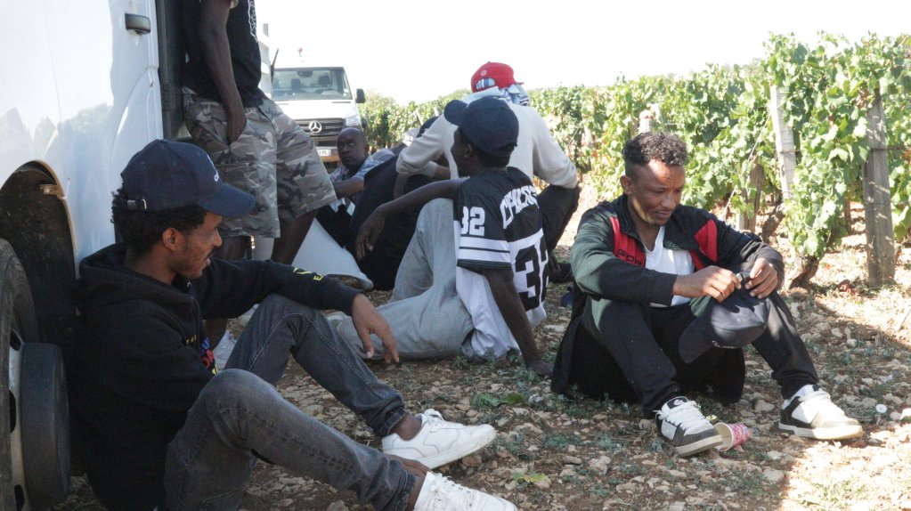 During their break, these Sudanese migrants take shelter from the sun in the shade of the trucks | Photo: InfoMigrants