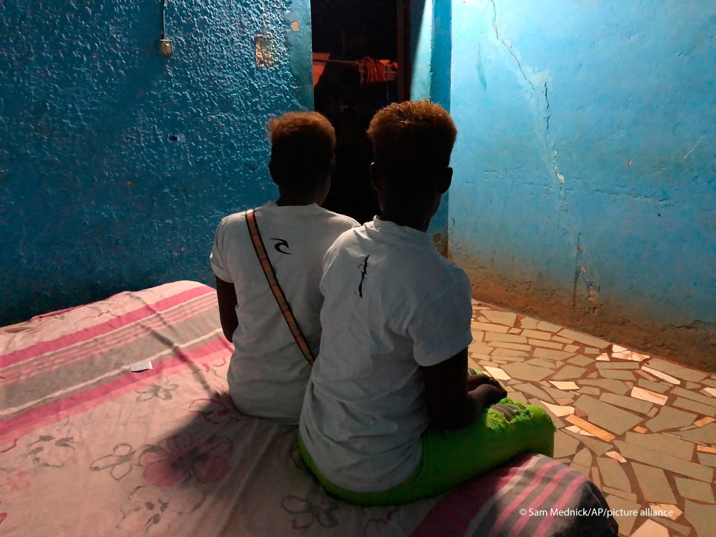 Two Nigerian sex workers sit on a bed in a room. Now free from their captors, they're too ashamed to return home without money so they continue sex work | Photo: AP/Sam Mednick