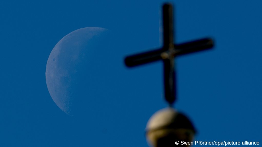 From file: The waning quarter moon can be seen in the German city of Kassel behind a church cross at St. Elisabeth's Church | Photo: Swen Pförtner/picture-alliance