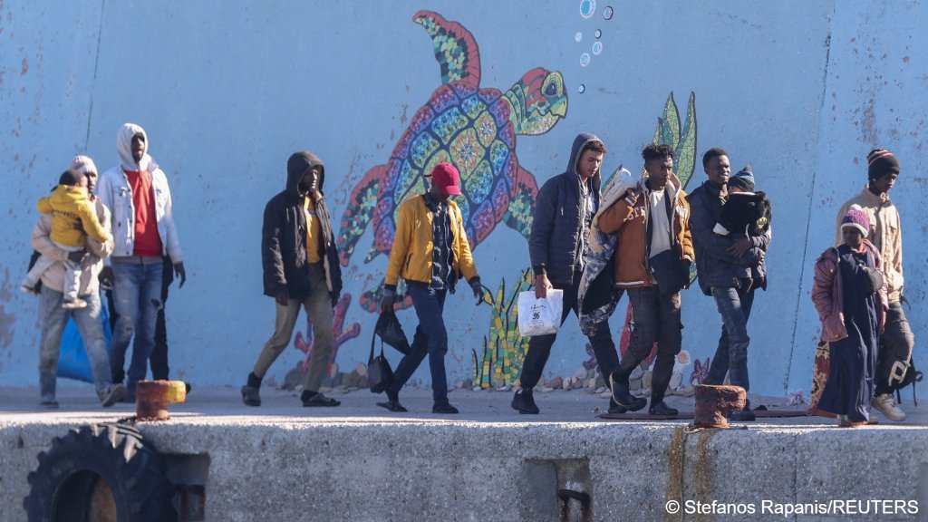 A group of migrants saved during a search operation off Gavdos island are pictured walking to board buses in the port of Agia Galini on Crete to be transferred to a temporary facility in Greece on December 19, 2025 | Photo: REUTERS / Stefanos Rapanis 