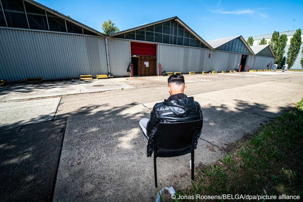 مهاجر يجلس خارج مركز الاستقبال الجديد في بيرلار ، بلجيكا