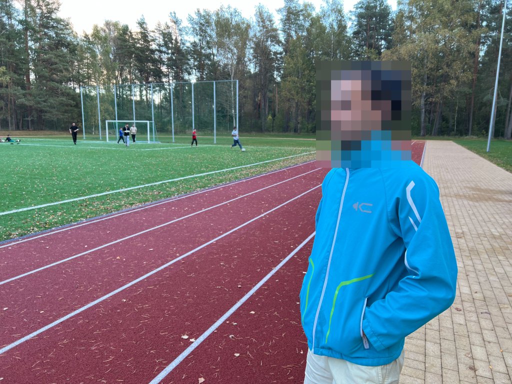 Abbas, an Iraqi migrant with refugee status, standing next to a soccer field in the village of Mucenieki in Latvia on September 29, 2024 | Photo: Benjamin Bathke/InfoMigrants