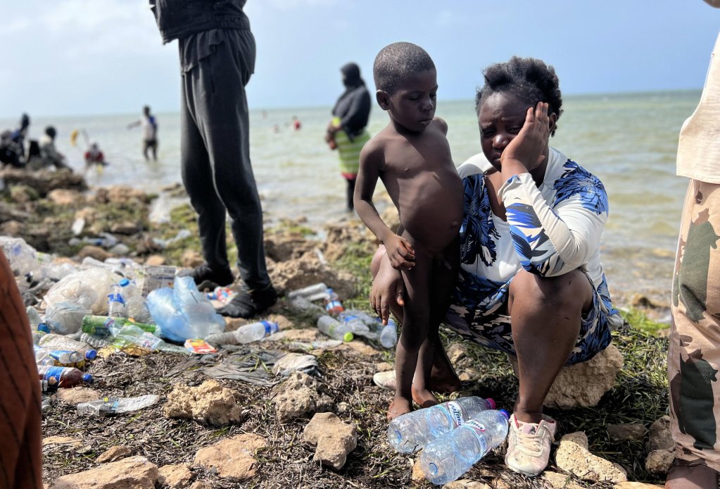 File photo: A woman sits with a boy among Sub-Saharan African migrants who were expelled from the city of Sfax in Tunisia and sent to an area near the Libyan-Tunisia border, in Ras Jedir, Libya, July 2023 | Photo: EPA 