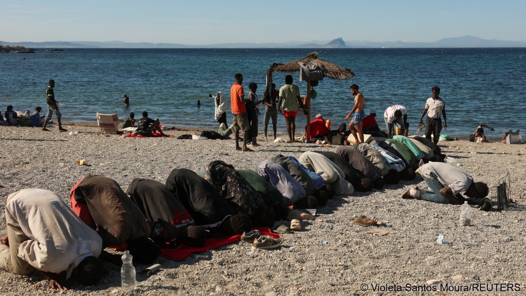 Migrants pray while waiting on a beach in Ceuta, Spain, following deadly mass crossings of migrants on foot and by sea from Morocco into Spanish territory, August 3, 2026 | Photo: Violeta Santos Moura / Reuters