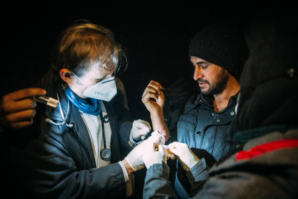 الطبيب الألماني غيرهارد ترابرت يعالج مهاجرا في شمال غرب البوسنة في يناير/ كانون الثاني 2021.
