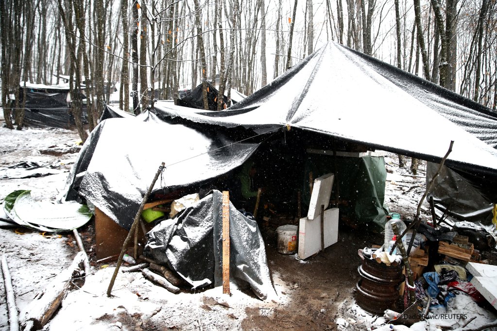 Migrants cook inside a tent in a makeshift camp during snowfall in a forest near Velika Kladusa, Bosnia and Herzegovina, 31 January 2021 | Photo: Reuters/Dado Ruvic