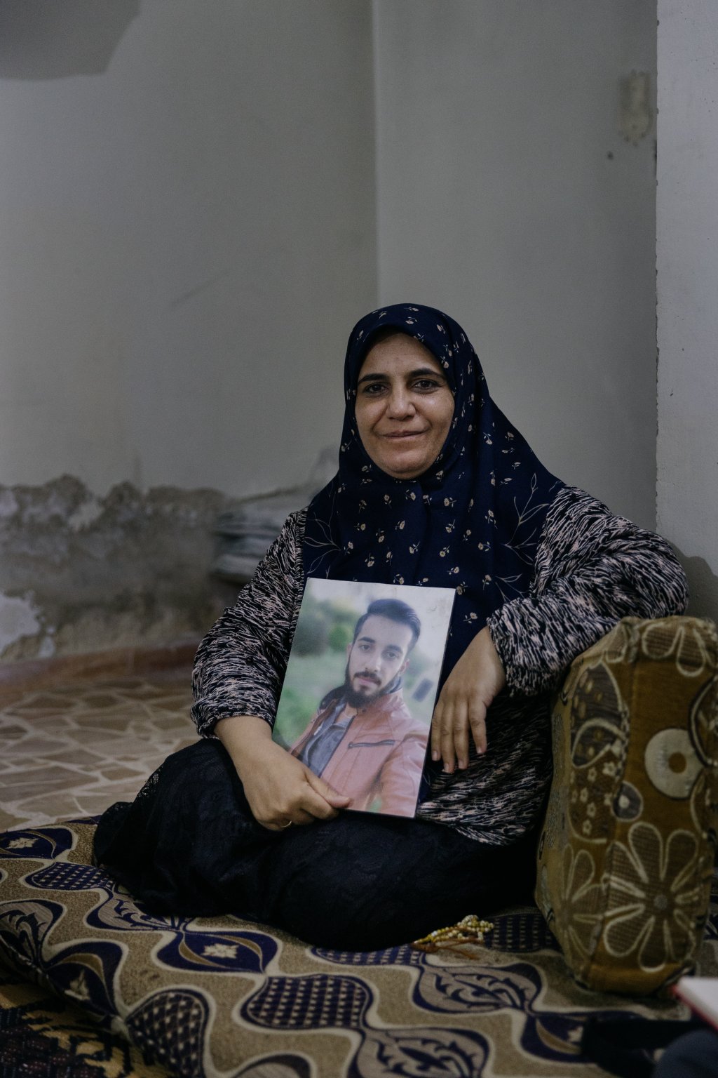 Mustafa's mother with her son's portrait in her hands | Photo: Valentina Camu / InfoMigrants
