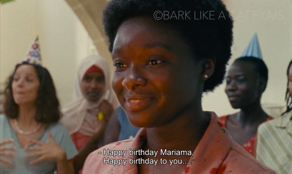 A screenshot from the film, showing Mariama and friends celebrating her 18th birthday, a bittersweet moment for the young migrant, who by becoming an adult will also be evicted from the center where she had been living | Source: Screenshot from 'The Lion at my Back' by Tonia Mishiali / Bark like a cat films