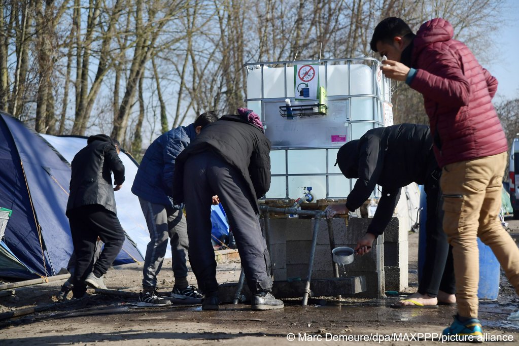 Aid groups in Grande-Synthe outside Calais are seen providing water for sanitation to migrants sleeping rough on March 8, 2022 | Photo: Picture-alliance/dpa/Marc Demeure