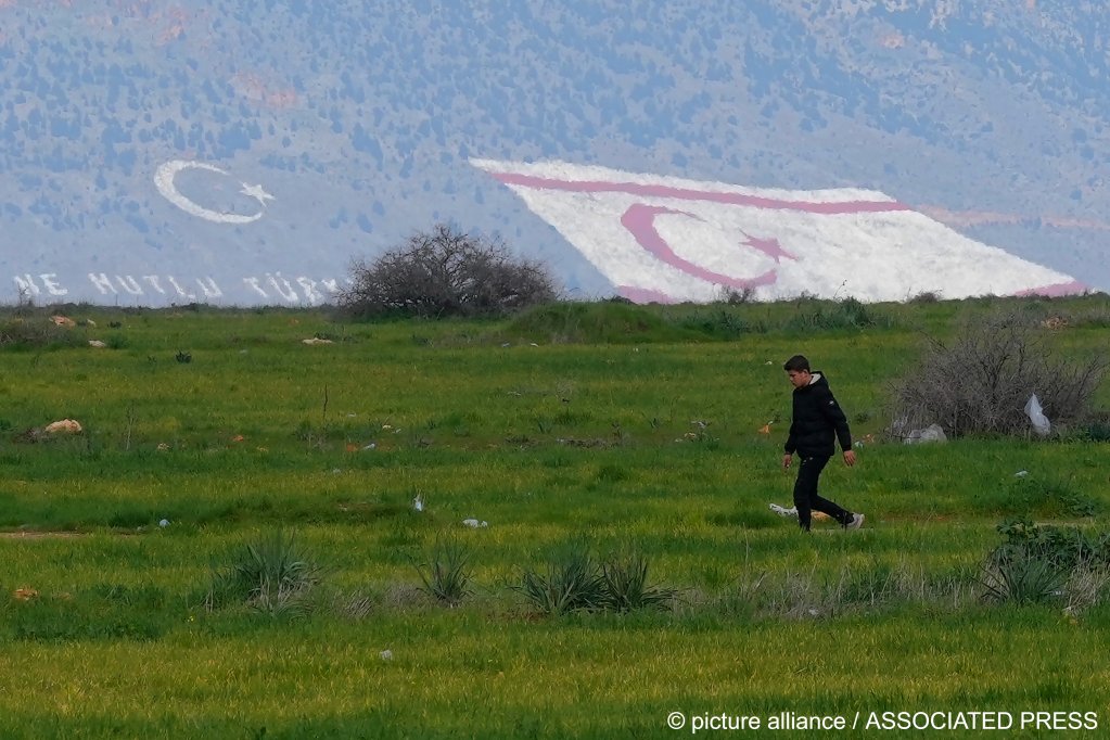 A migrant is seen walking near the Pournara migrant reception center in the Republic of Cyprus on Wednesday, February 09, 2022 - while in the distance, the self-declared TRNC is seen etched into the ground | Photo: Picture-alliance