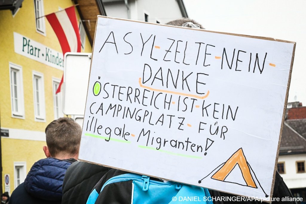 'Asylum tents, no thanks! Austria is not a campsite for illegal migrants!," a banner reads at a 'community information and protest march against tents for asylum seekers in Thalham' on October 26, 2022 in St. Georgen Im Attergau, Austria | APA/Daniel Scharinger/picture alliance