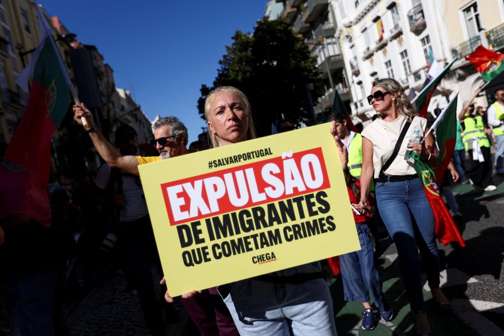 File photo used as illustration: A woman holds a placard calling for migrants who commit crimes to be expelled, during a Chega supporters rally in September 2024, according to a barometer, around 68 percent of Portuguese consider immigration policy to be too permissive | Photo: Rodrigo Antunes / Reuters