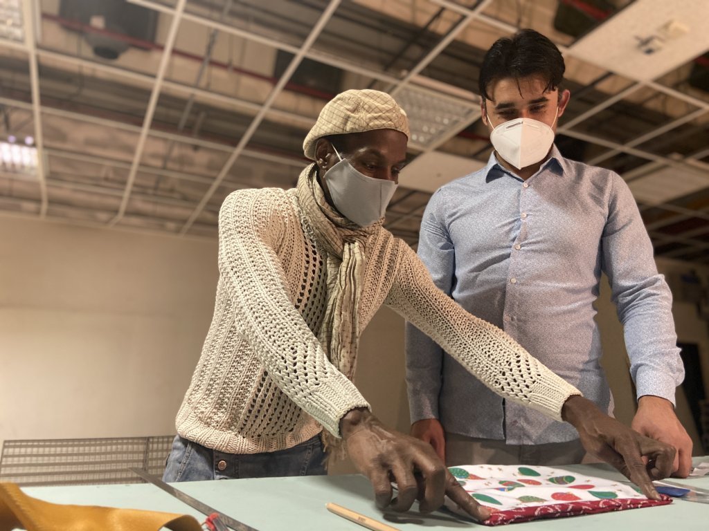 Thierry (left), a Parisian stylist and model maker, supervises the refugee team. Credit: Anne-Diandra Louarn / InfoMigrants
